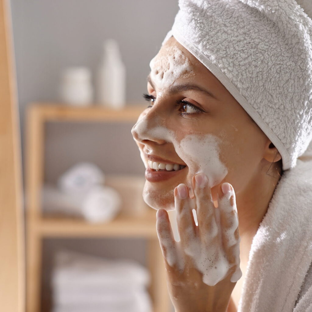 A woman applying the M.A.D Skincare Mega Rich Antioxidant Cleansing Gel on her face