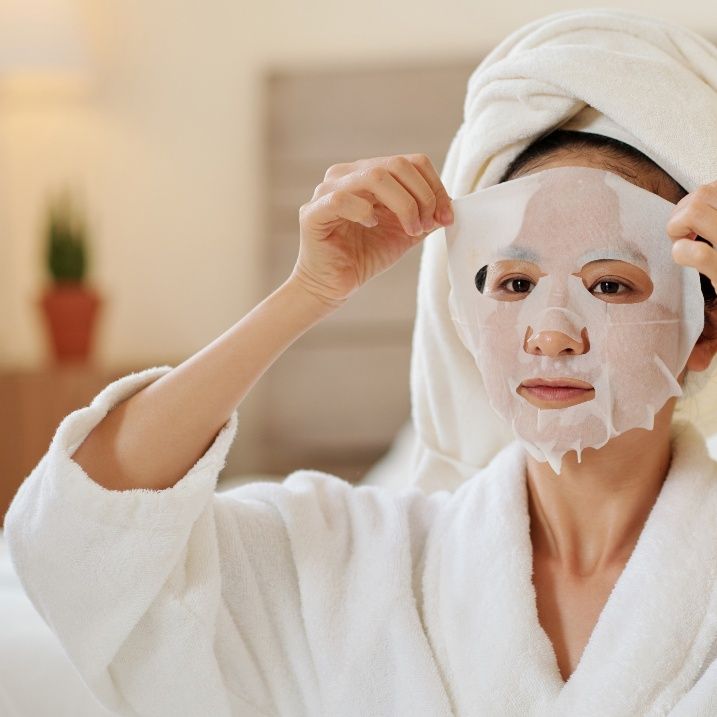 A woman applying M.A.D Skincare Facial Mask