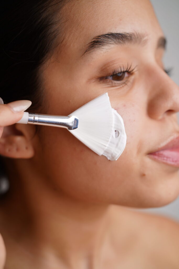 A woman applying Radiant Brightening Mask on her face