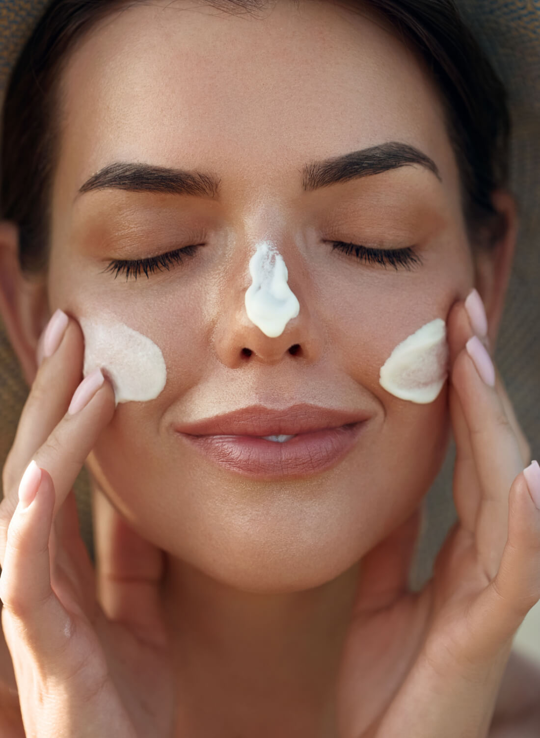 A woman applying Sunscreen on her face